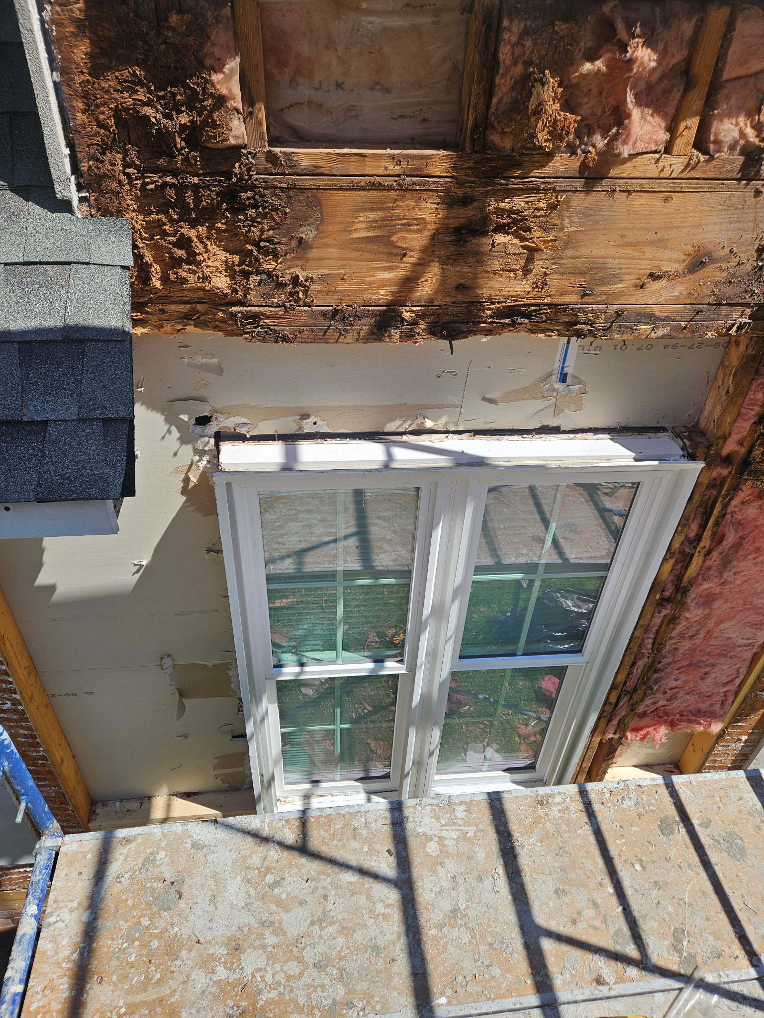 Water-damaged framing around a window behind EIFS
